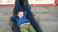 Een jongen (G-sporter VE) rust uit in een hangmat