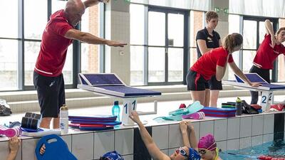 Open training zwemmen, ligatrainer Greg demonstreert de correcte techniek