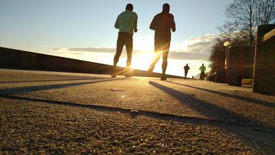 Twee lopers bij zonsondergang