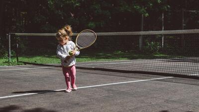 Kind houdt tennisracket vast